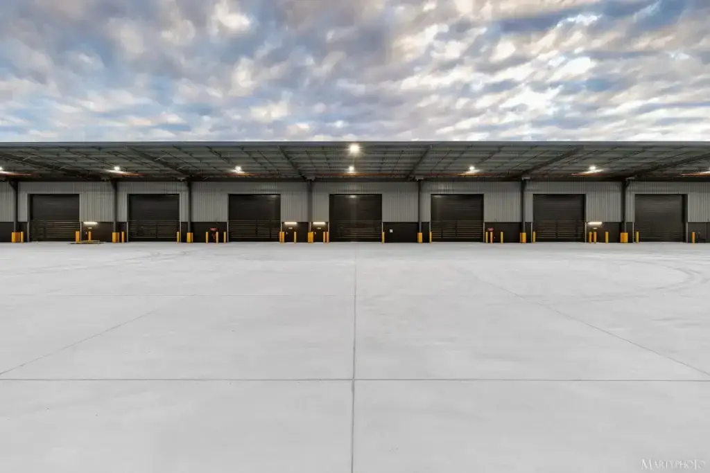 Symmetrical view of multiple industrial roller doors beneath metal roofing installed by Envy Roofing in Carole Park